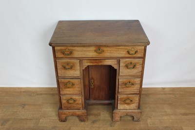 Lot 1269 - George II mahogany kneehole dressing table, the top with re-entrant angles and seven drawers and flush concealed apron drawer about the cupboard kneehole, 76cm x 50cm x 80cm