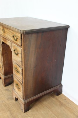 Lot 1269 - George II mahogany kneehole dressing table, the top with re-entrant angles and seven drawers and flush concealed apron drawer about the cupboard kneehole, 76cm x 50cm x 80cm