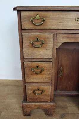 Lot 1269 - George II mahogany kneehole dressing table, the top with re-entrant angles and seven drawers and flush concealed apron drawer about the cupboard kneehole, 76cm x 50cm x 80cm