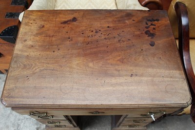 Lot 1269 - George II mahogany kneehole dressing table, the top with re-entrant angles and seven drawers and flush concealed apron drawer about the cupboard kneehole, 76cm x 50cm x 80cm