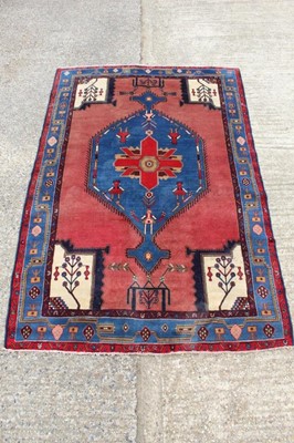 Lot 1430 - Eastern rug with conjoined medallion and figural motifs on salmon ground, in meande4 borders, 244 x 162cm