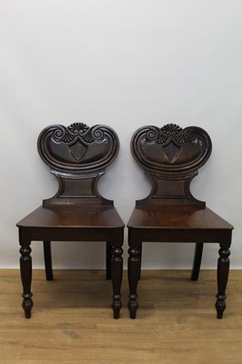 Lot 1356 - Pair of late Regency mahogany hall chairs, with Etruscan scroll backs and solid seats, on turned and sabre legs