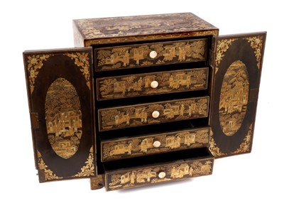 Lot 804 - 19th century Chinese lacquer table cabinet with gilt chinoiserie decoration and a pair of hinged doors opening to reveal five drawers to interior, on bracket feet. (with key). 30.5cm wide, 17.2cm d...