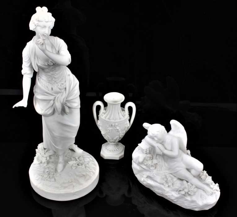 Lot 60 - A Derby bisque figure of a shepherdess, model number 369, 27.5cm high, together with a Derby vase, no. 115, and a bisque model of a reclining angel (3)