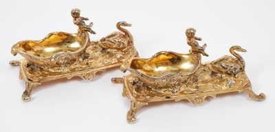 Lot 268 - Pair 19th century Continental silver gilt salts in the form of a putti riding a stylised shell, pulled by a swan, on four scroll feet(Import marks London 1891). all at approximately 8ozs. 11cm over...