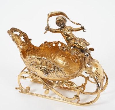 Lot 269 - Late 19th century Continental silver gilt bon bon dish in the form of a small child riding on a stylised shell sleigh (Import marks Chester 1899). All at approximately 7ozs. 15cm overall length.
