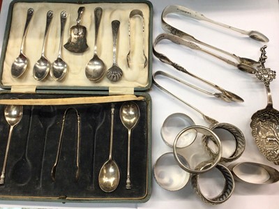 Lot 1088 - Six silver napkin rings, four pairs silver sugar tongs, one plated pair and various silver spoons