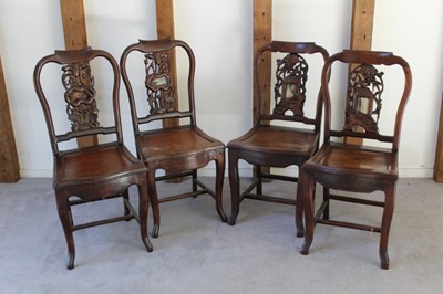 Lot 1224 - Two pairs of Chinese hardwood chairs with carved and pierced supports inset with hardstone panels (one lacking), serpentine shaped seats, on shaped legs