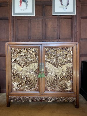 Lot 1219 - Chinese carved hardwood and parcel gilt cabinet, the twin doors decorated with phoenixes, carved frieze below, 117cm wide x 40cm deep x 108cm high