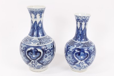 Lot 129 - Two similar 19th century Chinese blue and white bottle vases, both decorated with dragons, foliate patterns, ruyi symbols, etc, marks to bases, 22cm and 24.5cm high