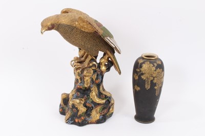 Lot 130 - A large Japanese Satsuma model of an eagle perched on a rocky outcrop, 30cm high, together with a Satsuma vase (2)