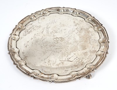 Lot 295 - George V silver salver of circular form with pie crust border, engraved initial 'G' to centre, raised on three scroll feet,(Sheffield 1913), maker William Hutton & Sons, all at 19ozs, 25.5cm in dia...