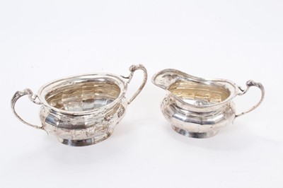 Lot 305 - George V silver milk jug of cauldron form, with faceted decoration and scroll handle, together with a matching sugar bowl, (Sheffield 1926), maker Lee & Wigfull, all at 15.5ozs, milk jug 15cm acros...
