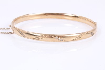 Lot 531 - 9ct gold hinged bangle set with diamonds