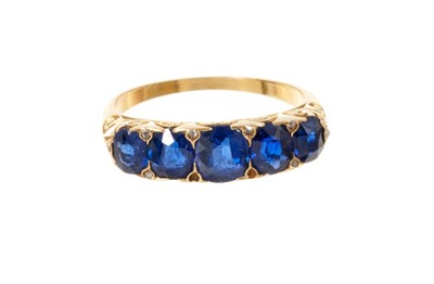 Lot 532 - Victorian sapphire five stone ring with oval mixed cut blue sapphires with diamond accents to the claws in carved gold setting, ring size M.