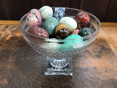 Lot 850 - Collection of polished carved hard stone eggs in cut glass pedestal bowl (18)