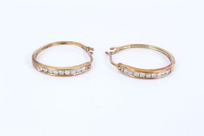 Lot 558 - Pair of diamond hoop earrings with brilliant cut diamonds in 9ct yellow gold channel setting, estimated total diamond weight approximately 0.18cts, approximately 18mm diameter.