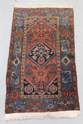 Lot 1441 - Small Eastern rug, with central serated medallion on brick red ground, in main meander border, 180 x 102cm