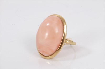 Lot 704 - Pink coral cabochon ring in yellow gold setting on 18ct gold shank