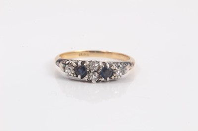 Lot 707 - Edwardian diamond and sapphire ring with four old cut diamonds and two mixed cut blue sapphires in claw setting on 18ct yellow gold shank