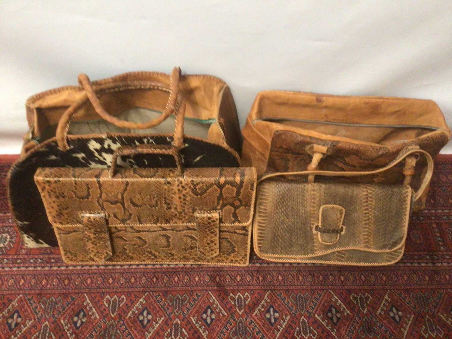 Lot 2124 - West African textiles to include snakeskin and leather bags, traditional tribal clothing.