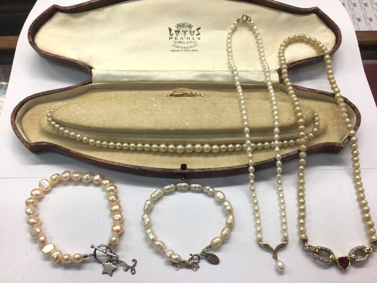 Lot 1009 - Two cultured pearl necklaces with 9ct gold clasps, simulated pearl necklace with silver gilt heart pendant and two pearl bracelets