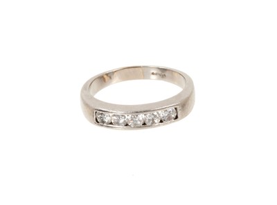 Lot 646 - Diamond and platinum half eternity ring with a band of five round brilliant cut diamonds in platinum channel setting. Estimated total diamond weight approximately 0.75cts.