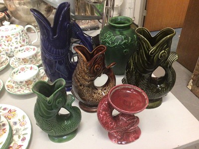 Lot 354 - Four pottery gluggle jugs, graduating in size, similar pottery classical dolphin candle holder and a vase (6)