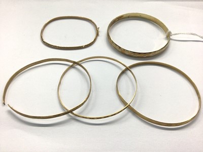 Lot 1033 - Four 9ct gold bangles and one silver gilt bangle