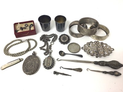 Lot 142 - Victorian silver locket on chain, late Victorian silver buckle, three engraved bangles, silver and mother of pearl fruit knife, two Russian silver measures, other silver and white metal items