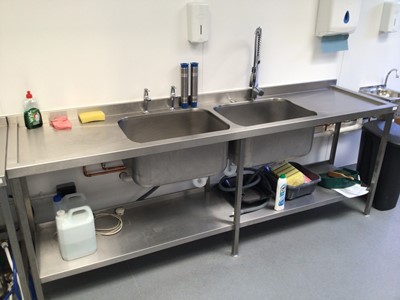 Lot 2 - A stainless steel double bowl sink unit with pre-rinse flexi-hose  tap and pair of taps, plus shelf under, 2400mm