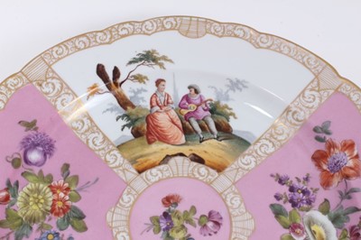 Lot 206 - A large pair of Dresden porcelain dishes, early 20th century, of scalloped form, decorated with figural panels on pink and yellow grounds, 'AR' marks to bases, 36cm diameter