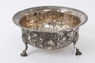 Lot 424 - Late Victorian silver sugar bowl of circular form in the Irish style, with embossed floral Chinoiserie decoration and flared crimped border, on three shell feet (London 1896) Wakely & Wheeler. All...
