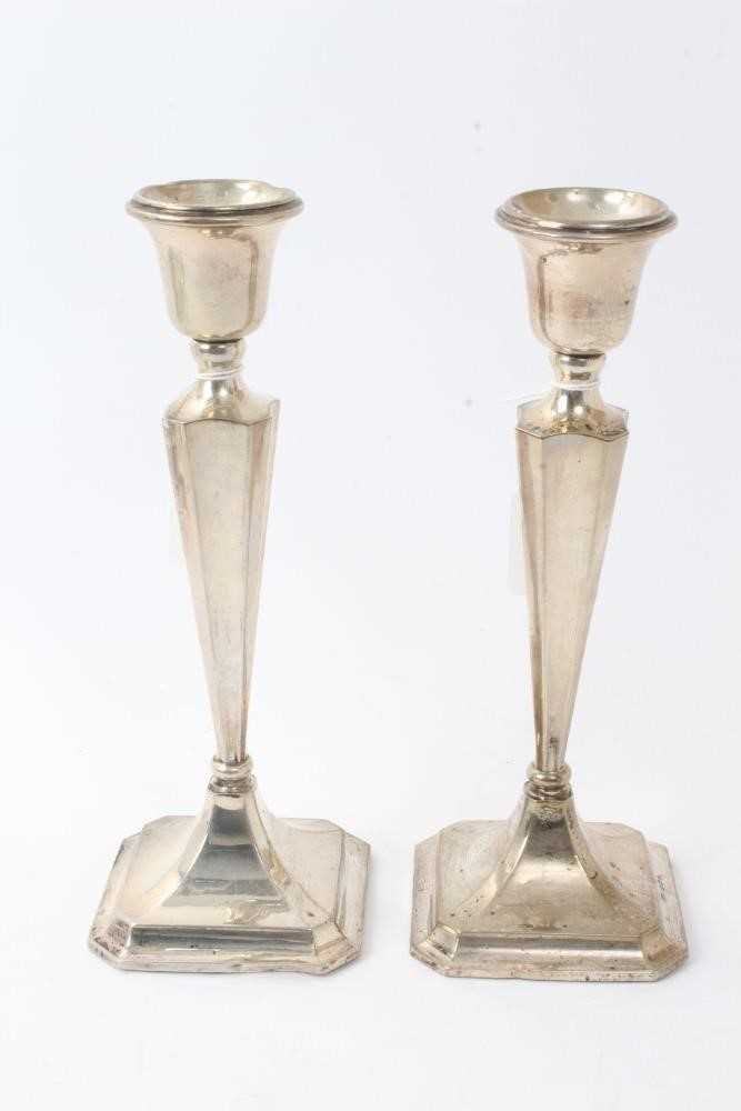 Lot 427 - Pair George V silver candlesticks with tapering octagonal stems and inverted bell candleholders, on octagonal pyramid bases, loaded (Birmingham 1918) Henry Williamson Ld. 26cm overall height.