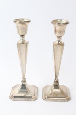 Lot 427 - Pair George V silver candlesticks with tapering octagonal stems and inverted bell candleholders, on octagonal pyramid bases, loaded (Birmingham 1918) Henry Williamson Ld. 26cm overall height.