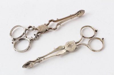 Lot 433 - Pair Georgian silver scissor action sugar nips with engraved armorial crest, together with another similar pair with engraved initials, both pairs marked on the handles. 11.5cm overall length. (2)