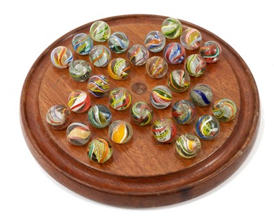 Lot 919 - Carved walnut solitaire board housing fine collection of 32 Victorian glass marbles