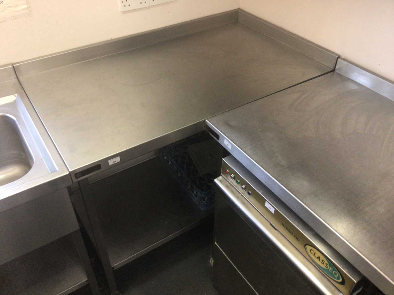 Lot 29 - A stainless steel corner wall mounted preparation bench, with undershelf, 1210 mm