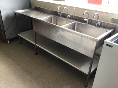 Lot 39 - A Portland stainless steel double bowl sink unit, with two pairs of taps and draining board, laminate shelf under, 2140 mm