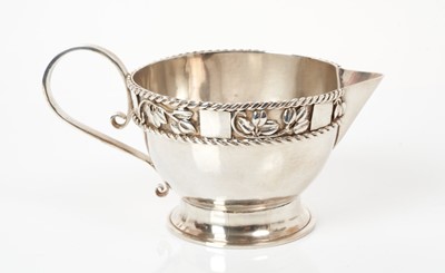 Lot 467 - George V silver Arts & Crafts silver milk / cream jug with applied foliate and rope twist border and overall planished finish, (Birmingham 1935), maker Charles Horner.