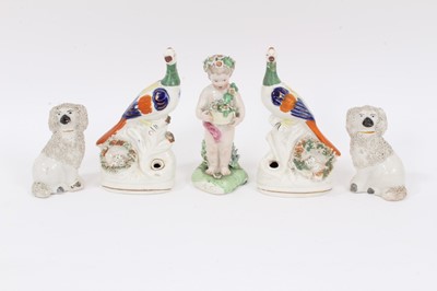 Lot 248 - A Derby figure of a cherub, circa 1800, together with a pair of Staffordshire exotic bird pen holders, and a pair of Staffordshire spaniels (5)