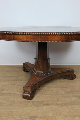 Lot 1401 - William IV rosewood circular breakfast table, the tilt top with beaded edge on facetted column and shaped triangular platform on scroll feet, 123cm diameter