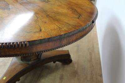 Lot 1401 - William IV rosewood circular breakfast table, the tilt top with beaded edge on facetted column and shaped triangular platform on scroll feet, 123cm diameter