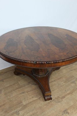 Lot 1401 - William IV rosewood circular breakfast table, the tilt top with beaded edge on facetted column and shaped triangular platform on scroll feet, 123cm diameter