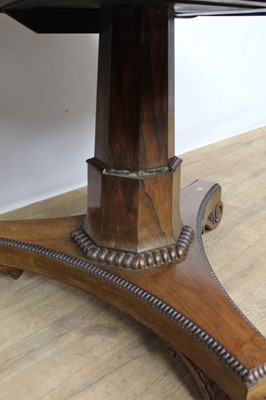 Lot 1401 - William IV rosewood circular breakfast table, the tilt top with beaded edge on facetted column and shaped triangular platform on scroll feet, 123cm diameter