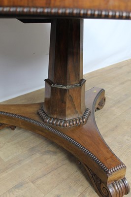 Lot 1401 - William IV rosewood circular breakfast table, the tilt top with beaded edge on facetted column and shaped triangular platform on scroll feet, 123cm diameter