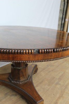 Lot 1401 - William IV rosewood circular breakfast table, the tilt top with beaded edge on facetted column and shaped triangular platform on scroll feet, 123cm diameter