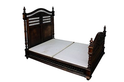 Lot 1422 - Ornate 19th century French carved chestnut double bed, with bobbin turned arched head and footboard centred by mask reserves, with conforming stretchers, 150cm wide