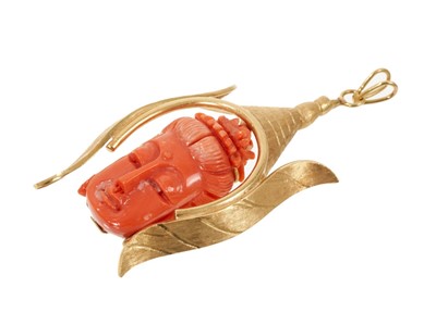 Lot 773 - Eastern carved coral pendant with a carved Buddha's head in a yellow metal mount, 82mm.