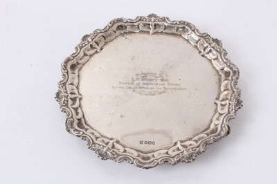 Lot 478 - George V silver waiter of circular from with shell and scroll border, raised on three similar feet, with later presentation inscription to centre, (Sheffield 1913), all at 11ozs, 19.5cm in diameter...